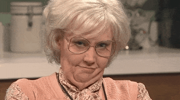 Kate McKinnon dressed as an old person and winking