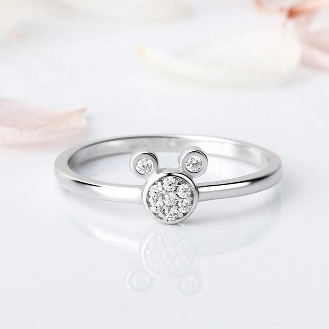 a silver ring with a cubic zirconia mickey head in the middle