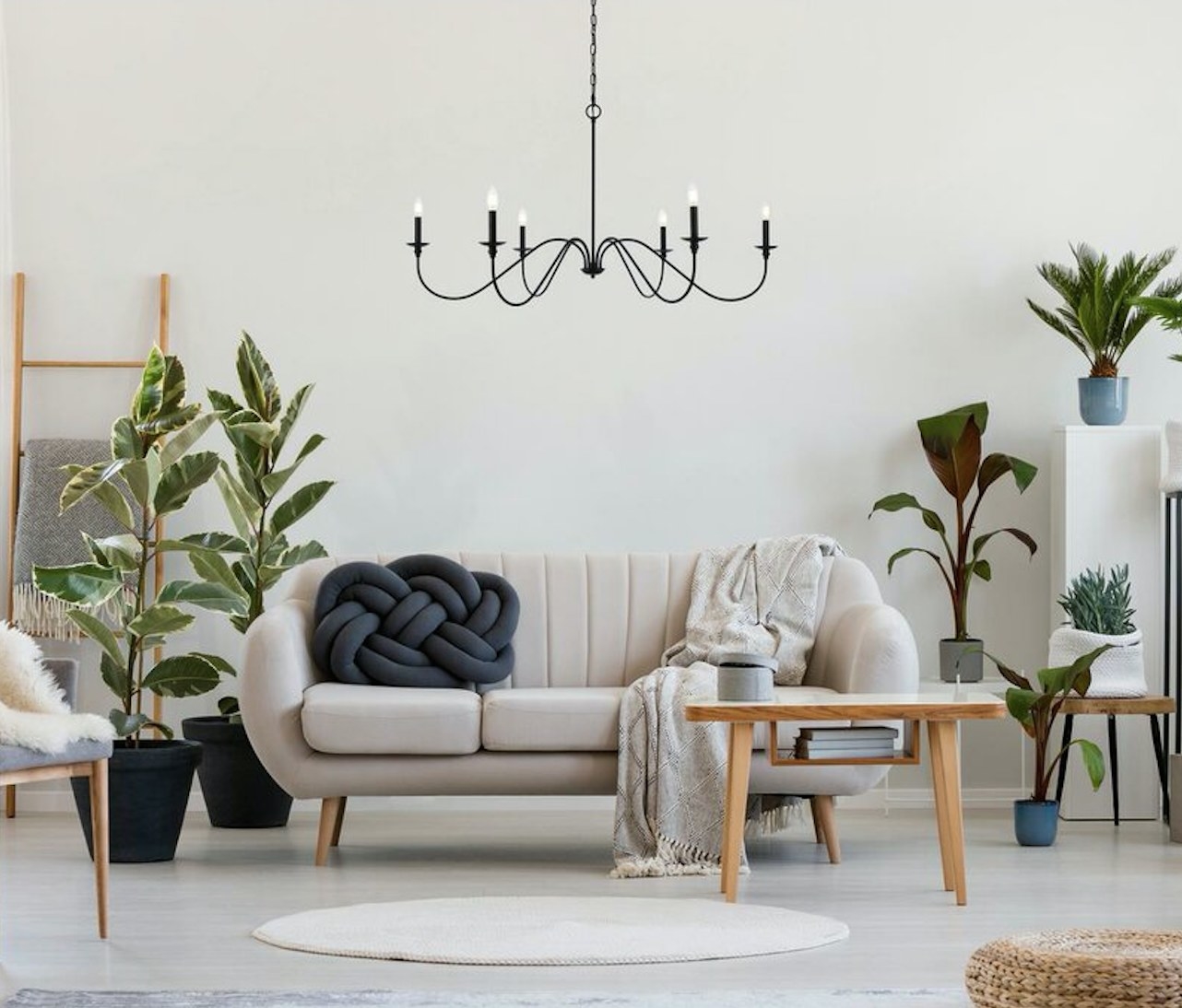 Black 6 light chandelier hanging over beige couch in living room