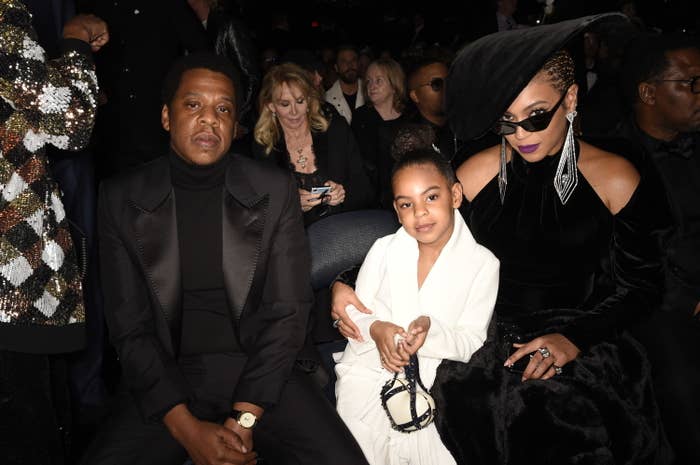Blue sits between her mom and dad at an event