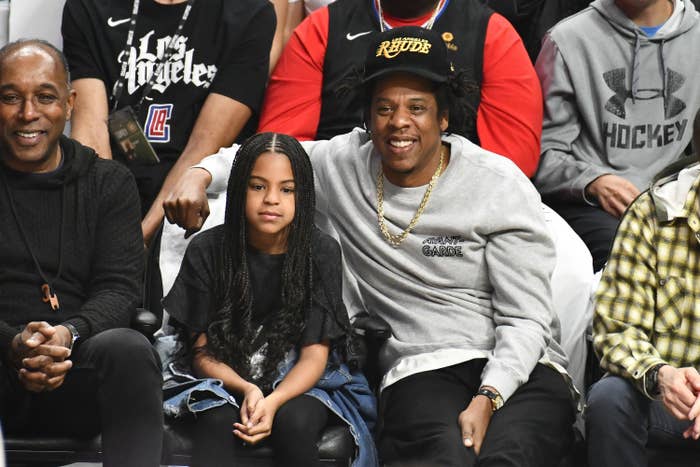 Blue sits next to her dad at a basketball game