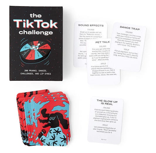 The card game laid out showing example challenges and the black box it comes in that reads &quot;TikTok challenge&quot;.