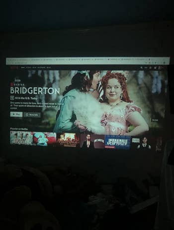 a reviewer shows the projector showing Netflix on their dorm room wall