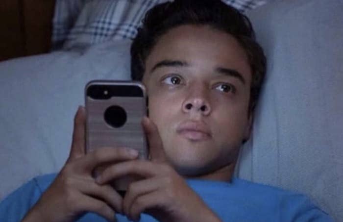 Guy from On My Block looking at his phone