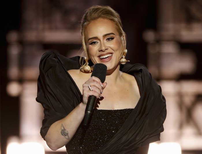Adele smiles while talking on stage