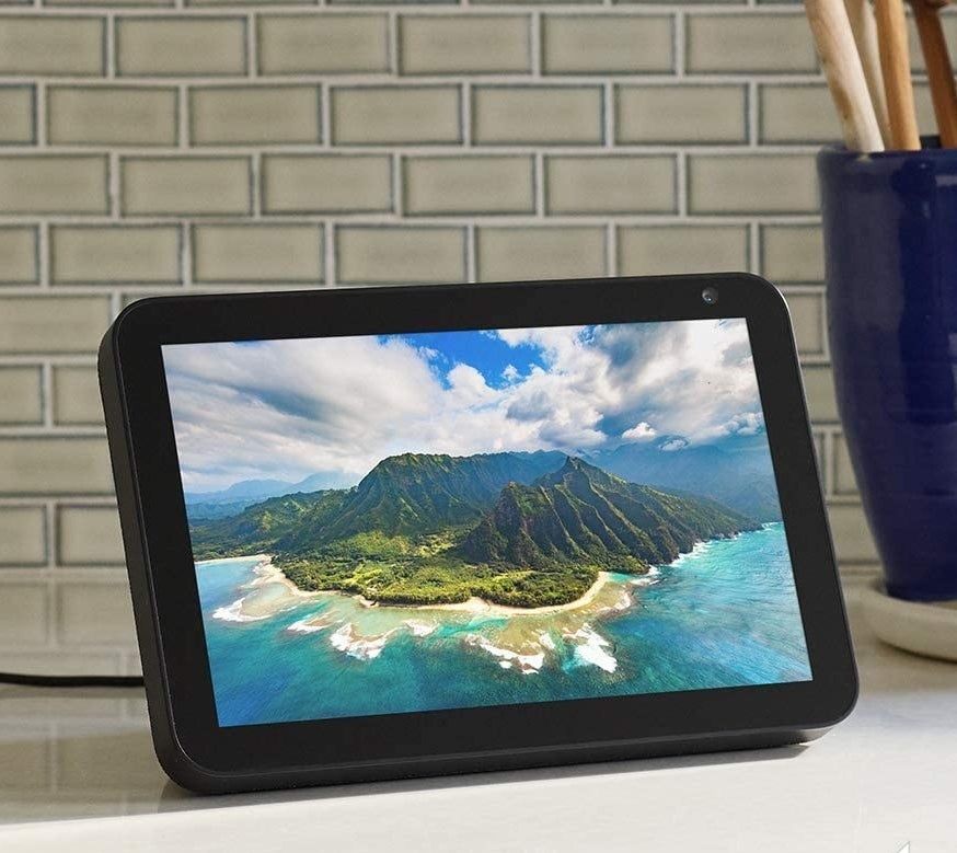 The Echo Show on a kitchen counter with a photo of a island on the display screen
