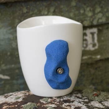 white mug with blue finger hold as the handle