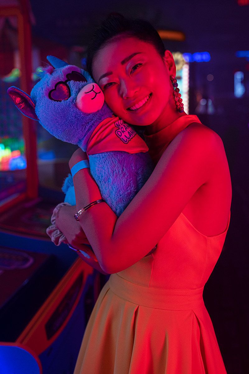 A woman holds a stuffed llama in the Midway at Dave &amp;amp; Buster&#x27;s.