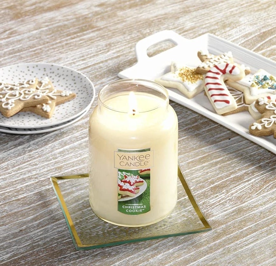 The lit Christmas cookie candle surrounded by plates filled with decorative cookies