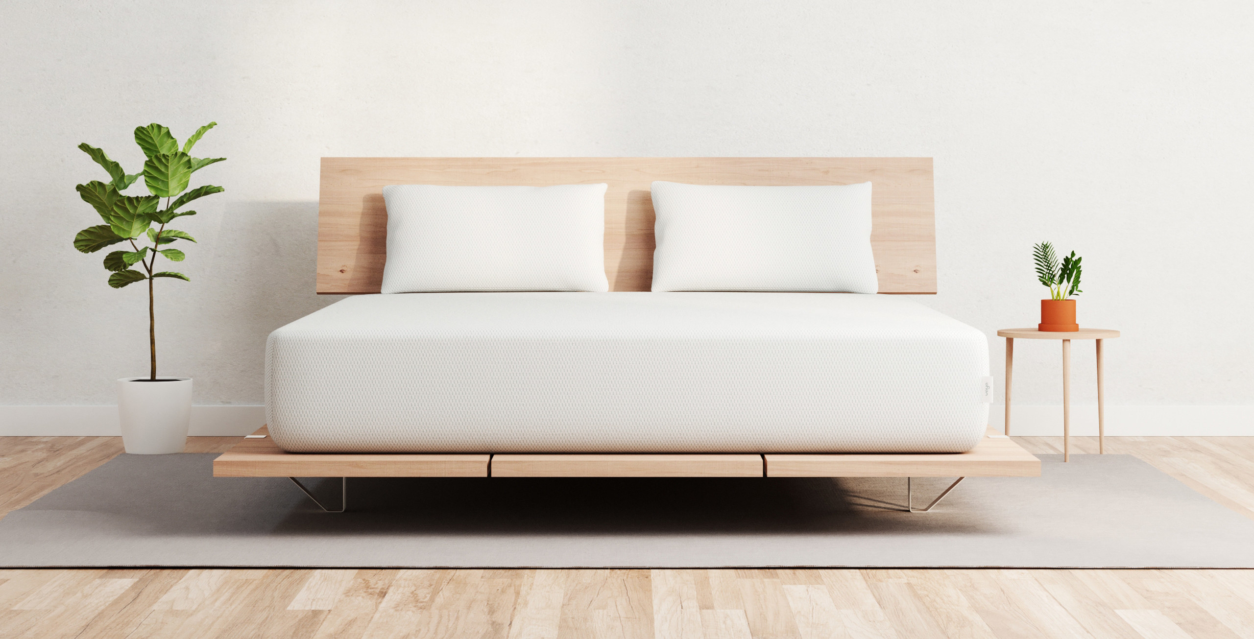 white mattress with two white pillows on top of wooden bed