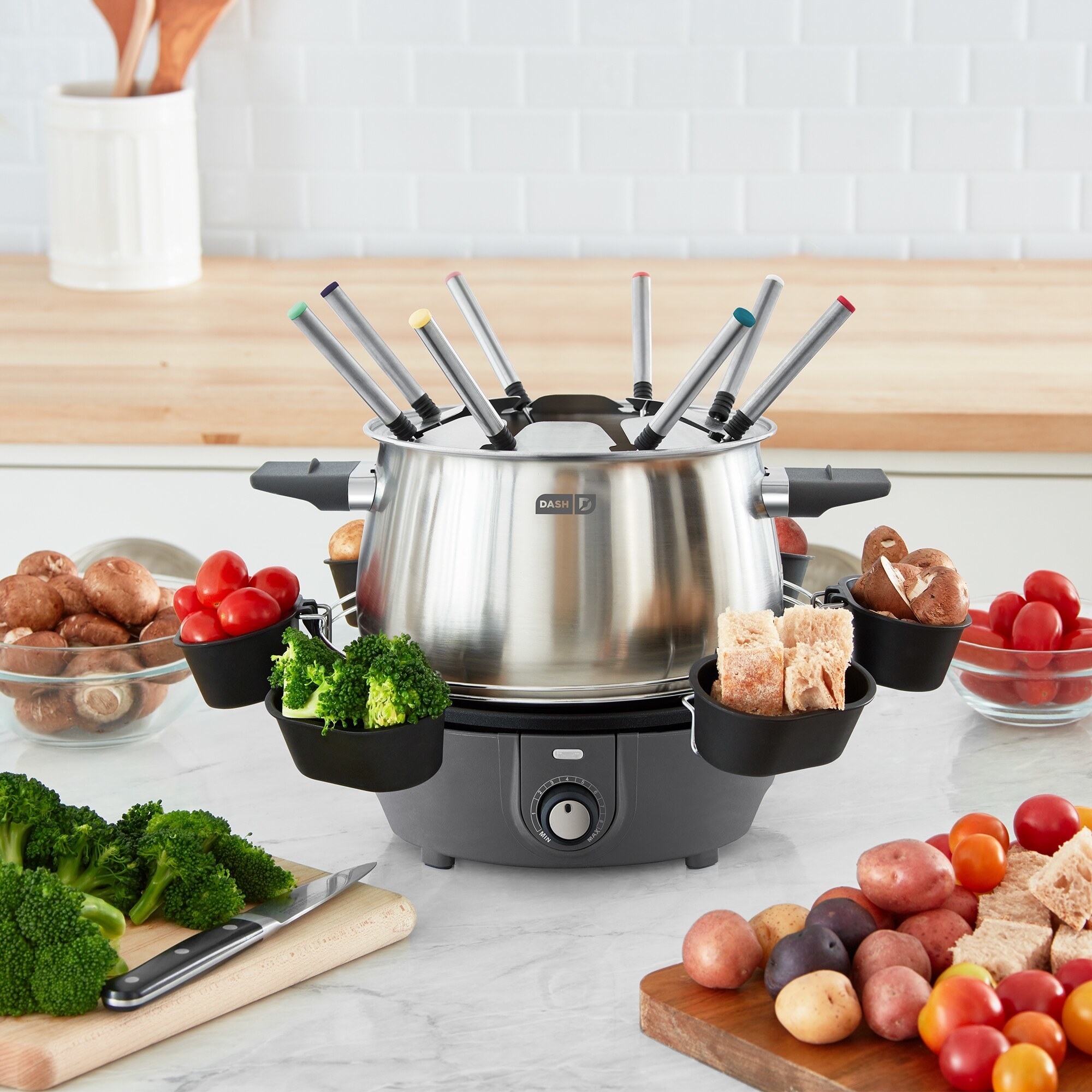 a metal fondue pot with forks sticking out the top and little pockets for ingredients