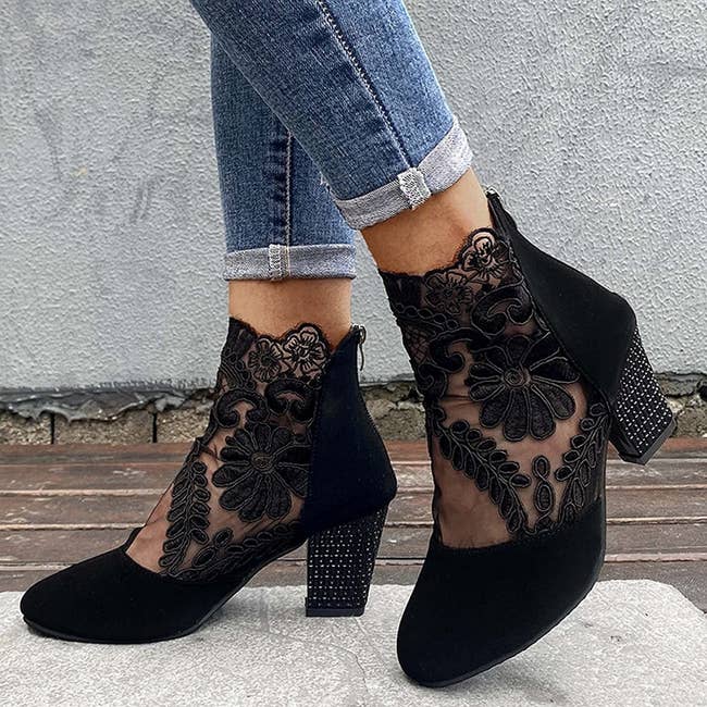 Model wearing the black lace heeled boots with cuffed jeans
