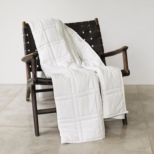 white weighted blanket on dark wood camp chair