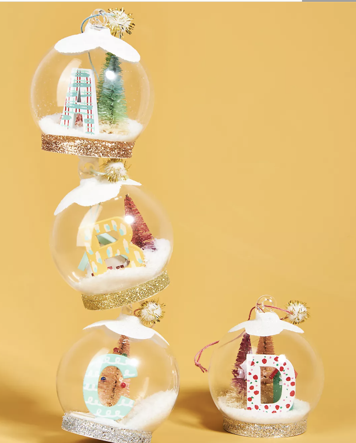 THe snow globe shaped ornaments with letters in them