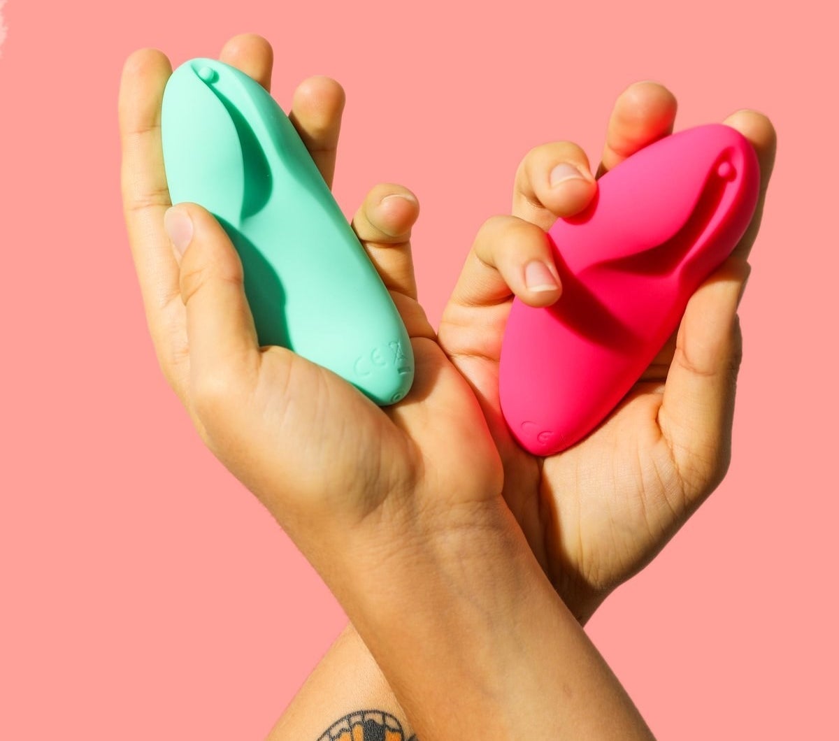 Models holding mint green and pink vibrators