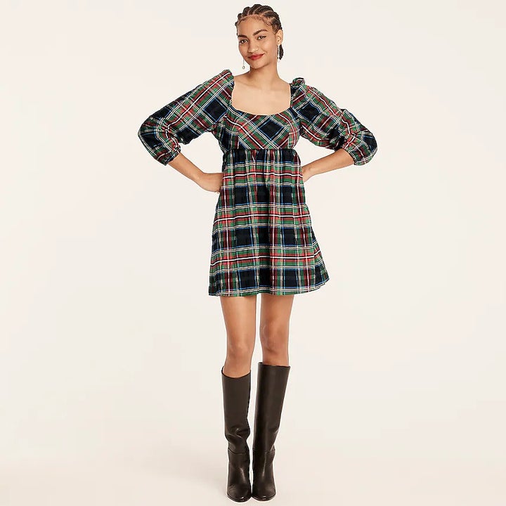 A model wearing a red, green, and black plaid puff-sleeve mini dress