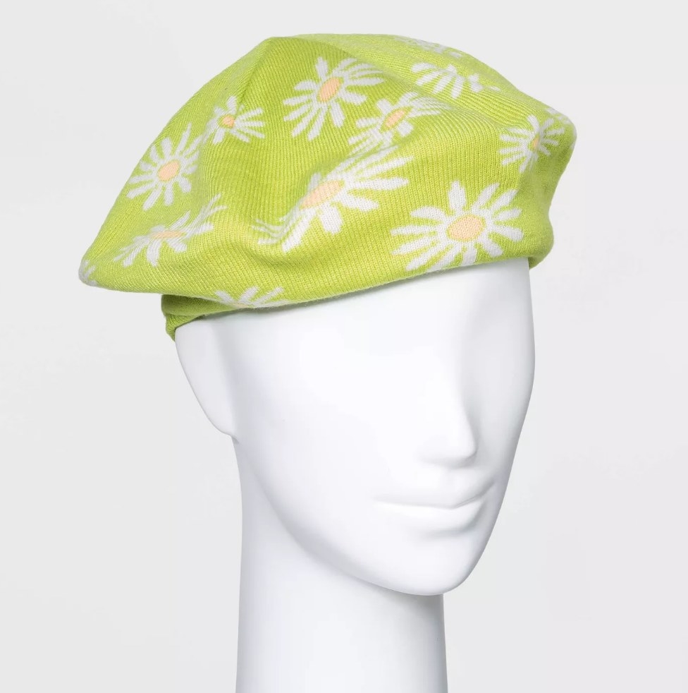 Green beret with white and yellow daisy design on mannequin head