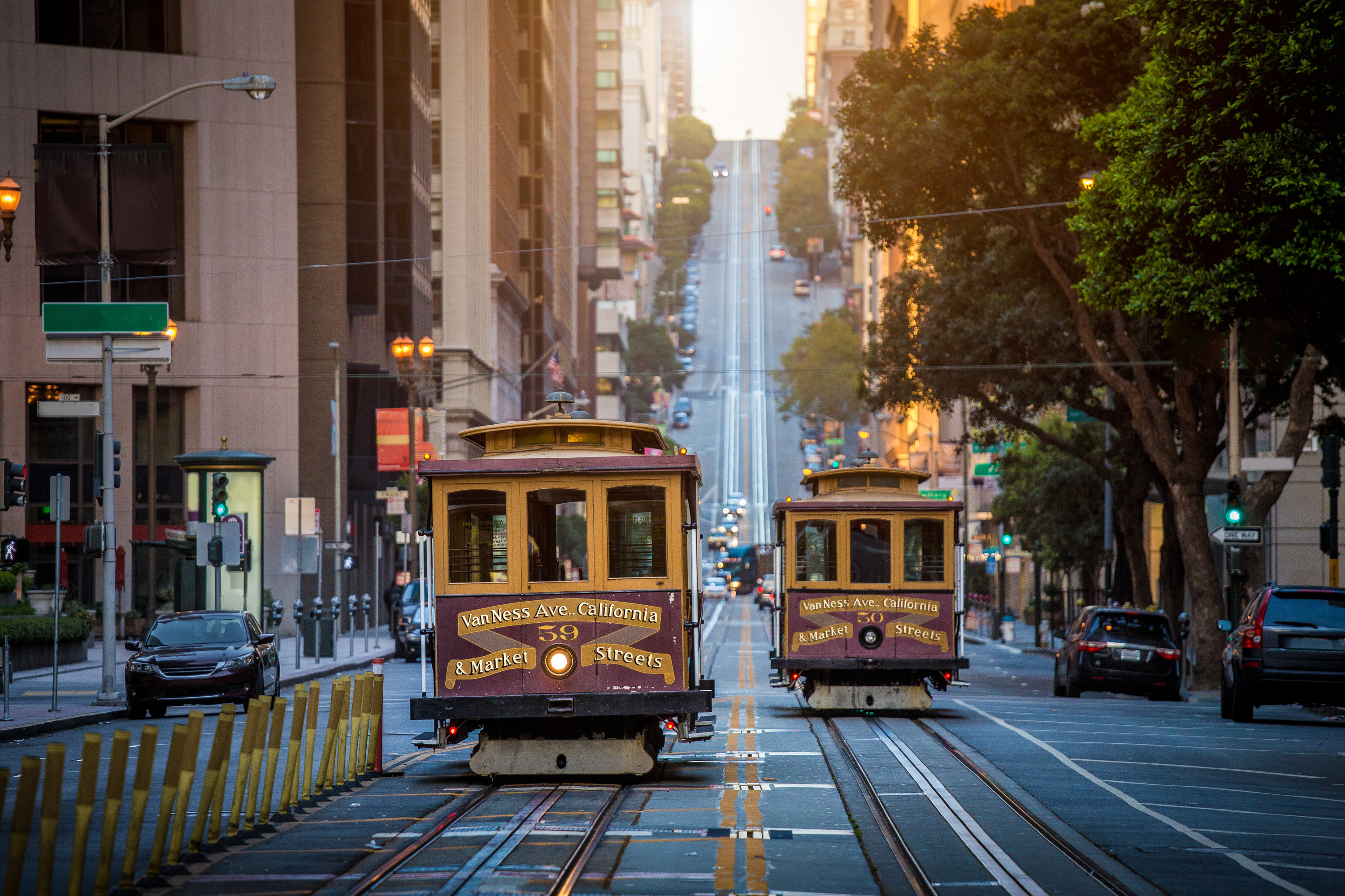 historic cable cars coming down a street with a steep incline in San Francisco