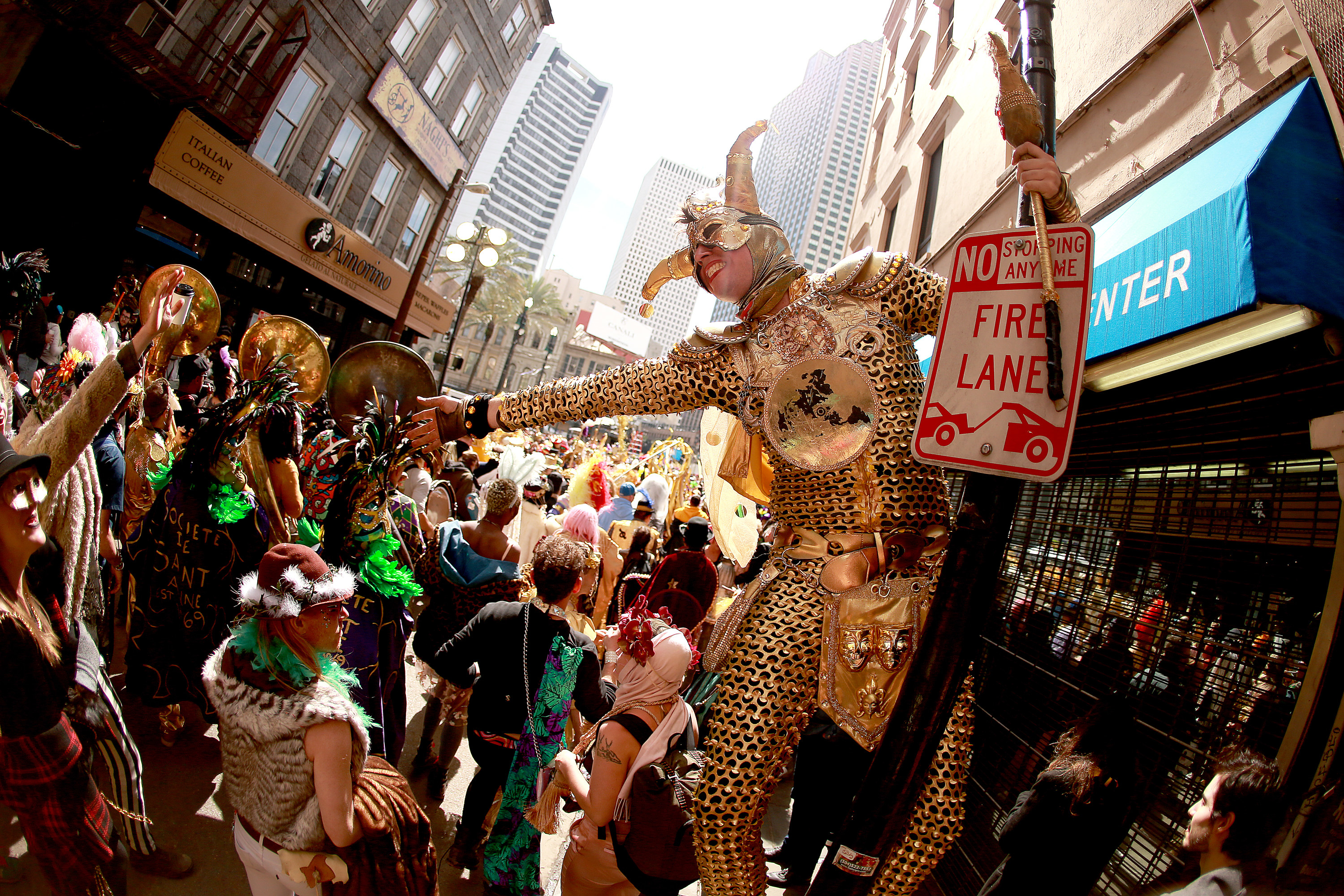 members of Krewe of Saint Anne march down the street during Mardi Gras in New Orleans