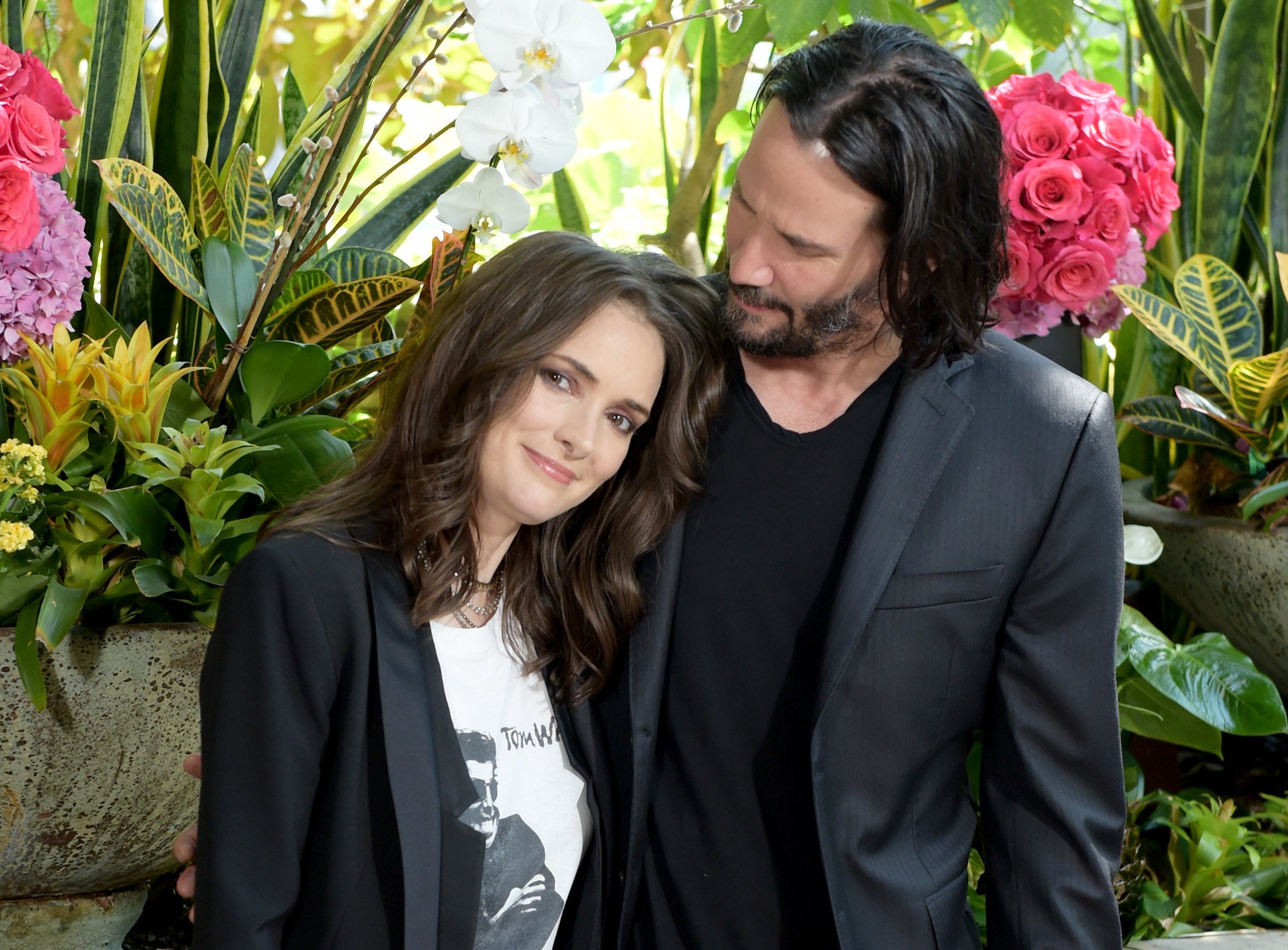 Keanu looks down at Winona while posing together recently
