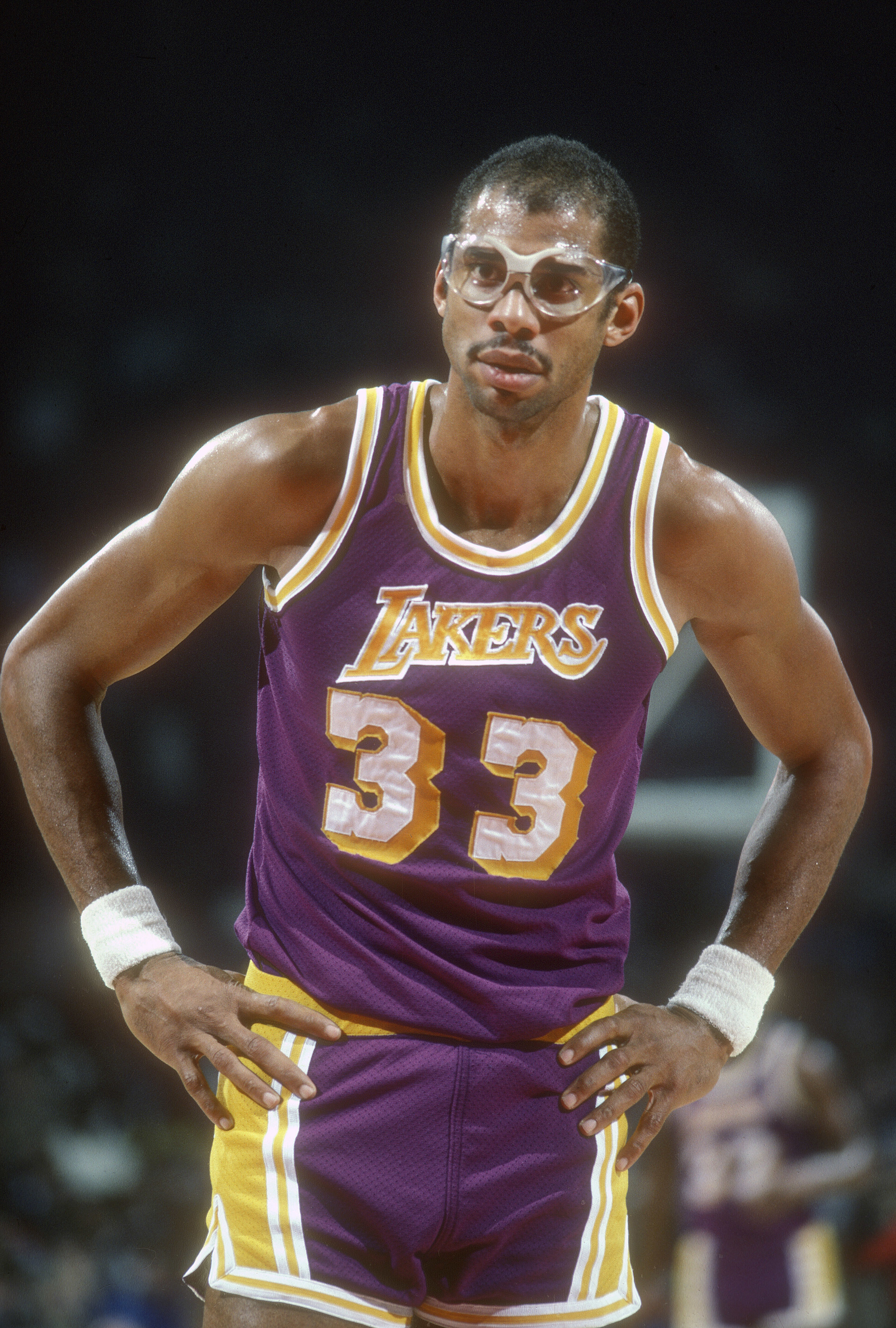 Kareem Abdul-Jabbar stands on the court in a Lakers uniform