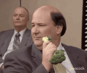GIF of Kevin from The Office sadly eating broccoli