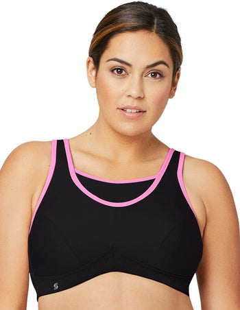 Front of model wearing black sports bra with pink trim