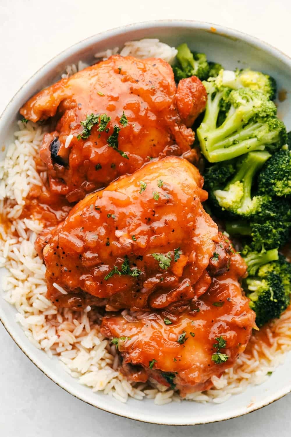 Apricot chicken over rice with broccoli.