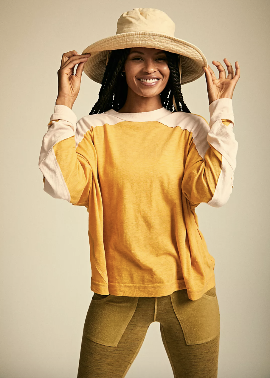 a model wearing the top in yellow and cream