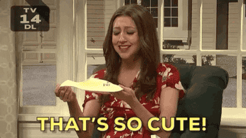 a gif of Heidi Gardner on &quot;Saturday Night Live&quot; holding up a bib and saying &quot;That&#x27;s so cute&quot;
