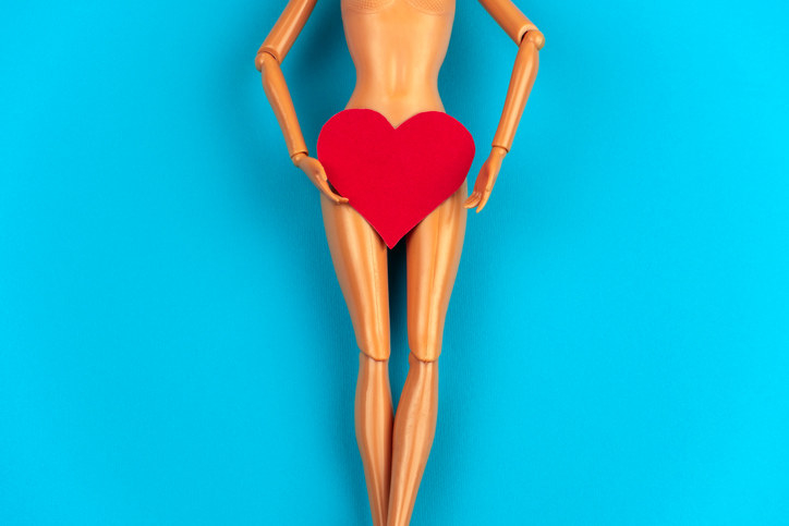 A nude doll with a heart over their pubic area