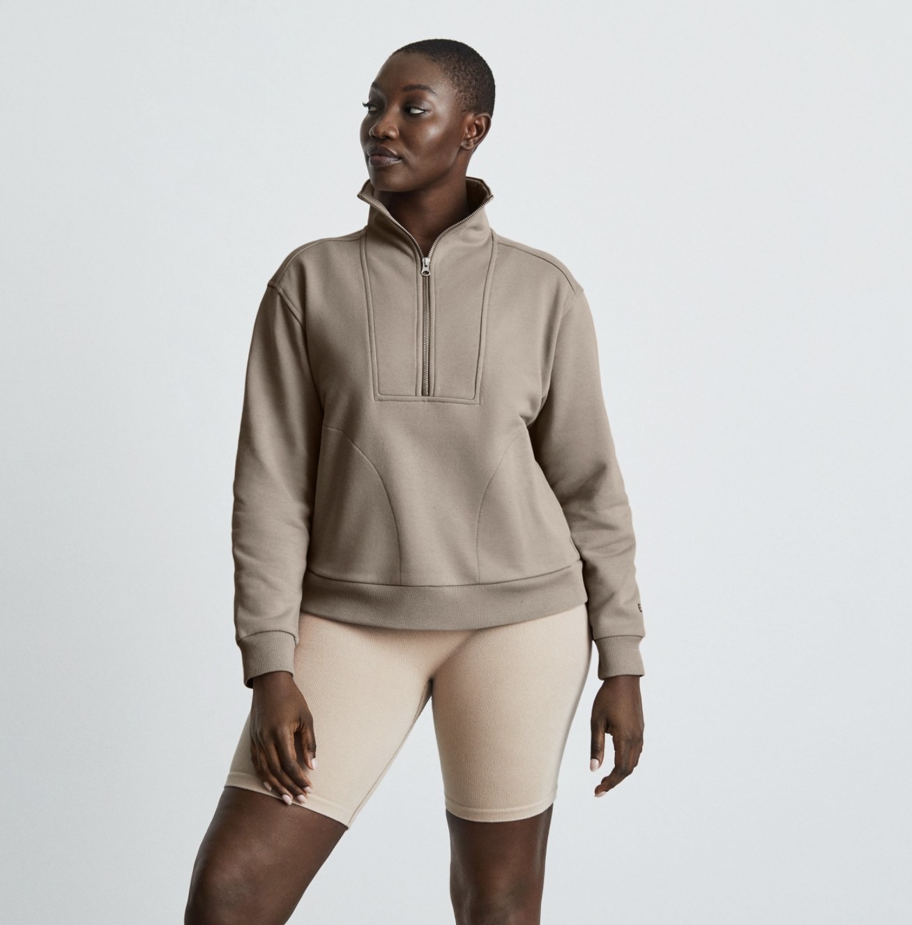 A model wearing the beige half zip