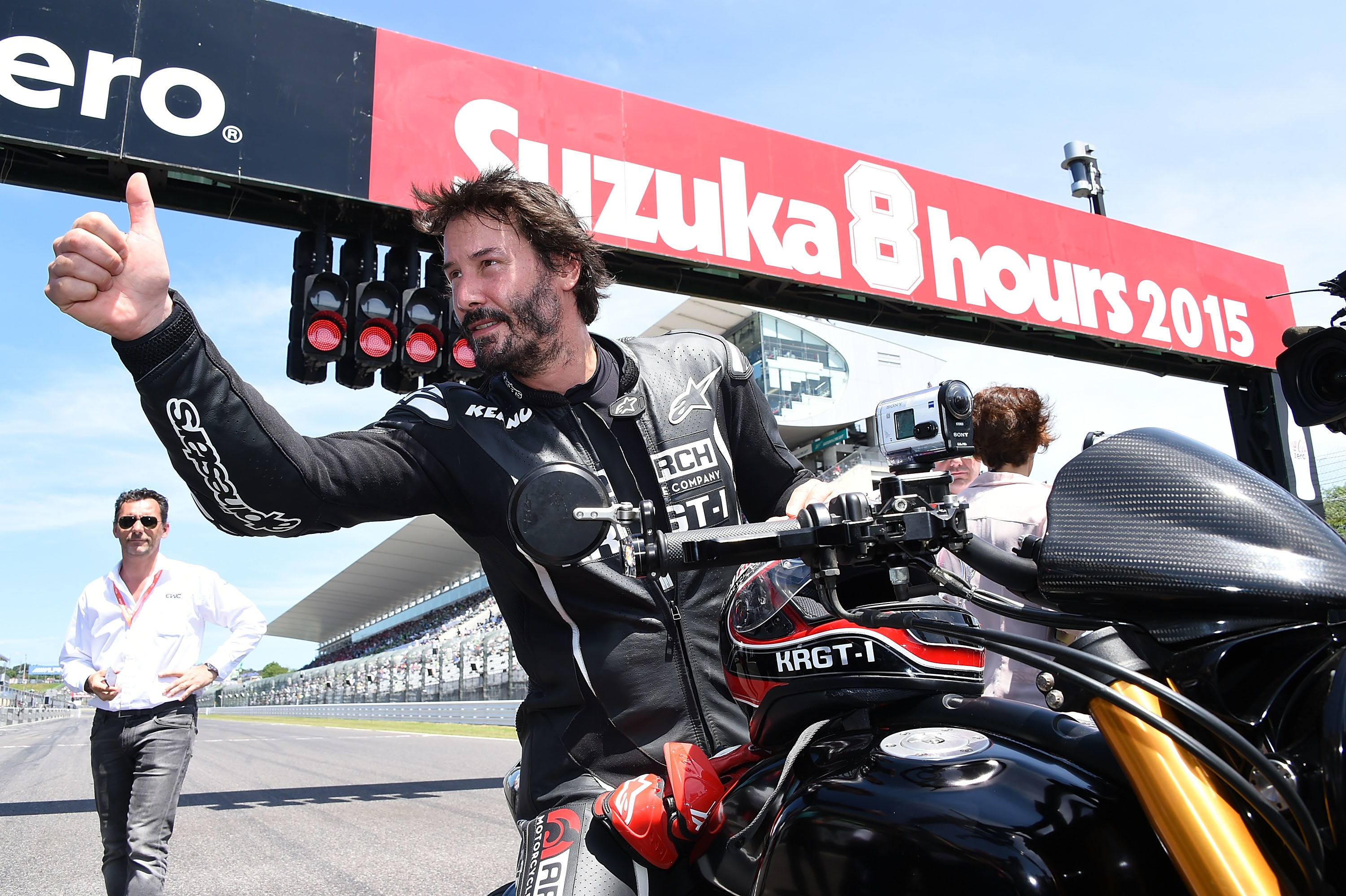 Keanu gives a thumbs up on a motocycle