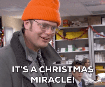 Dwight from &quot;The Office&quot; smiling in a beanie and looking at camera saying &quot;It&#x27;s a Christmas Miracle&quot;