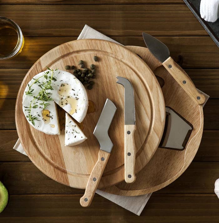 Two knives and a wheel of brie on the board