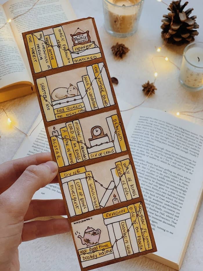 a hand holding a filled in bookshelf tracker bookmark