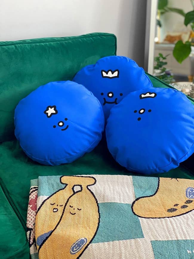three blueberry throw pillows on a couch