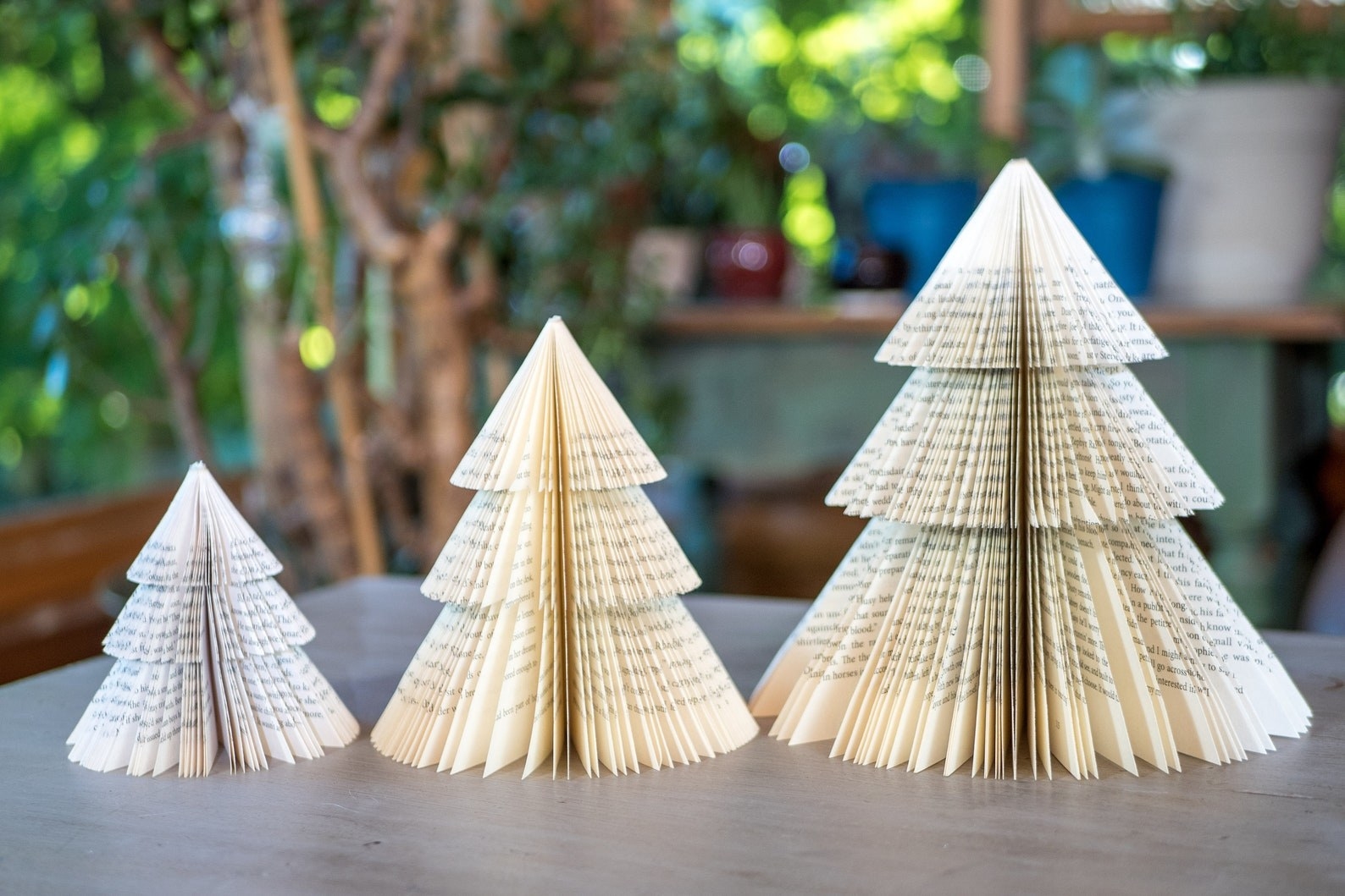 a set of three Christmas trees made from books