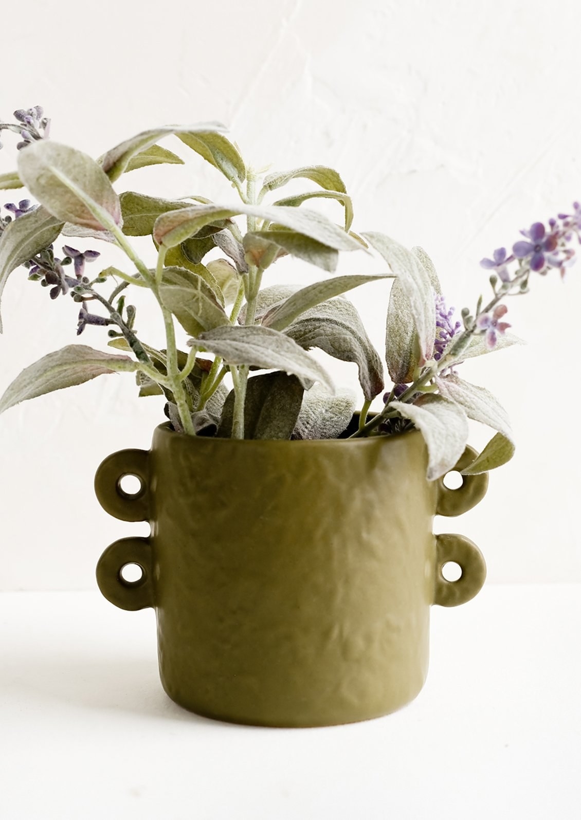 the green planter which has two small looped handles on each side