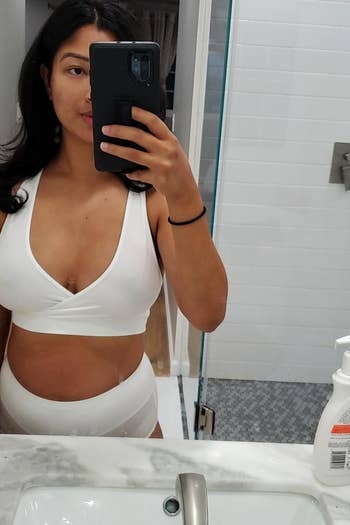 reviewer mirror selfie wearing the crisscross bra in white