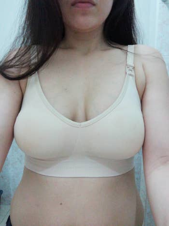 reviewer selfie wearing ivory colored nursing bra