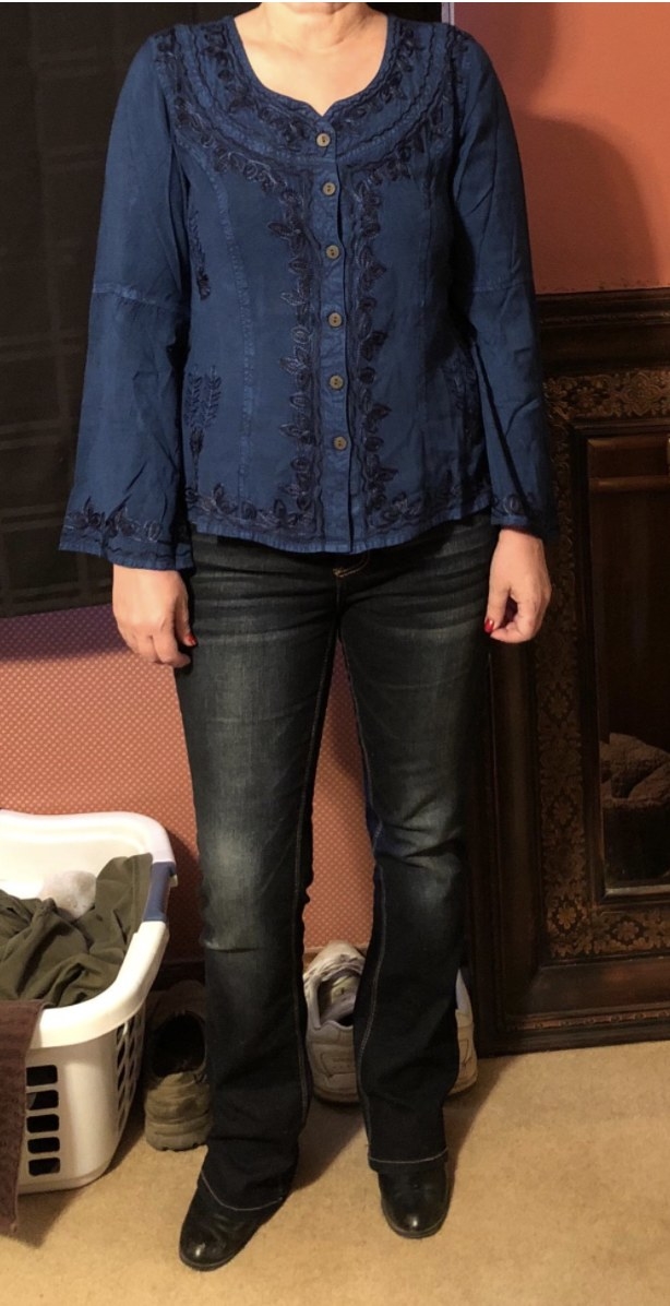 A reviewer wearing the dark blue curvy bootcut jeans with boots and blouse