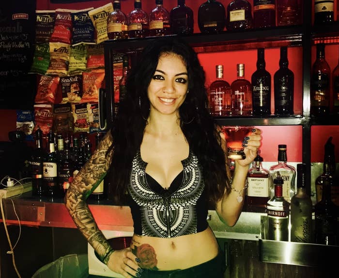 Writer of the article holding a cocktail behind the bar