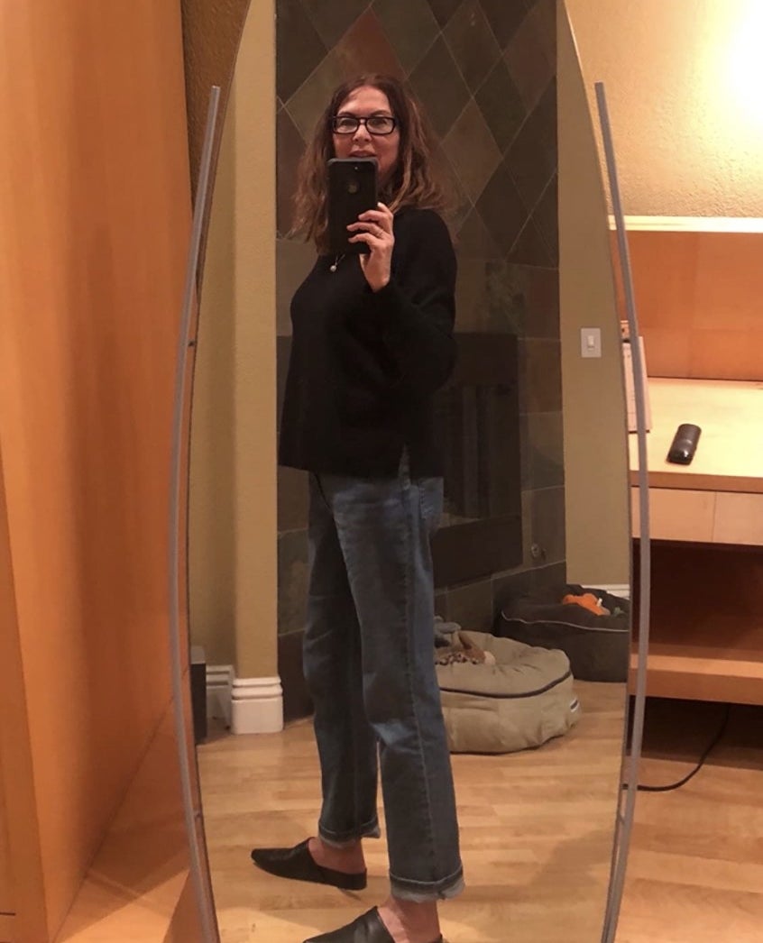 A reviewer&#x27;s selfie wearing the relaxed fit jeans cuffed at the ankles