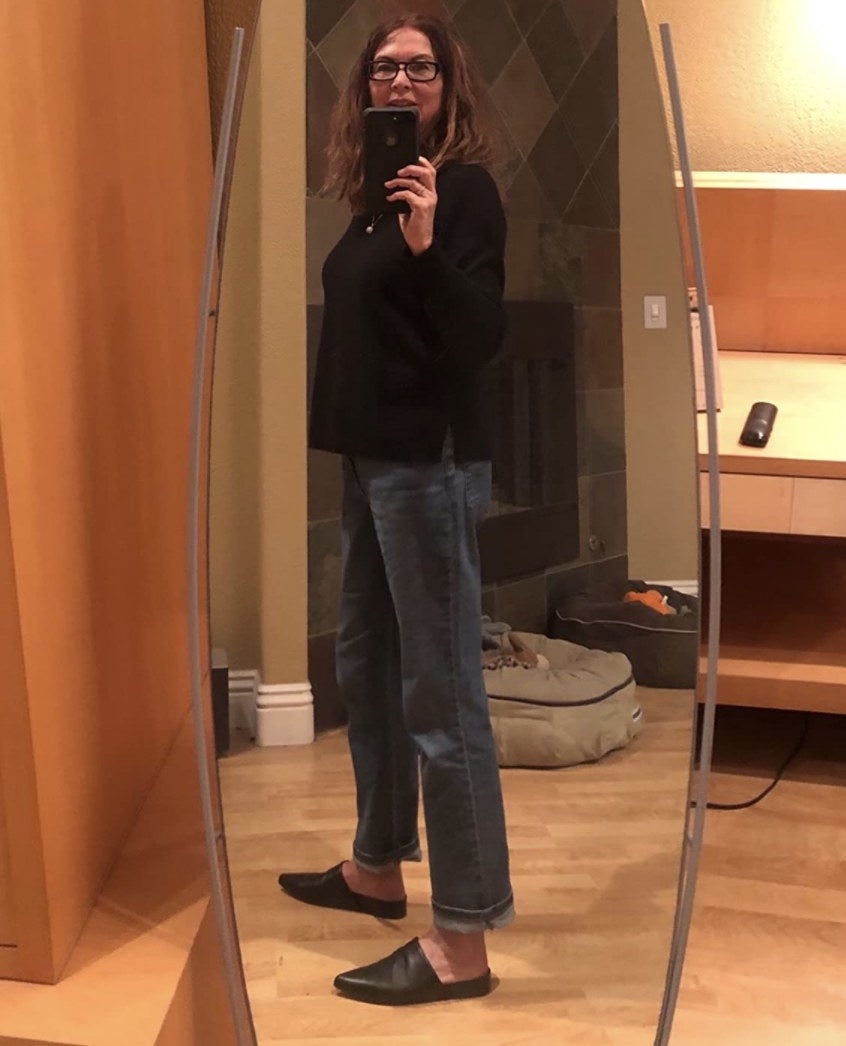 A reviewer's selfie wearing the relaxed fit jeans cuffed at the ankles