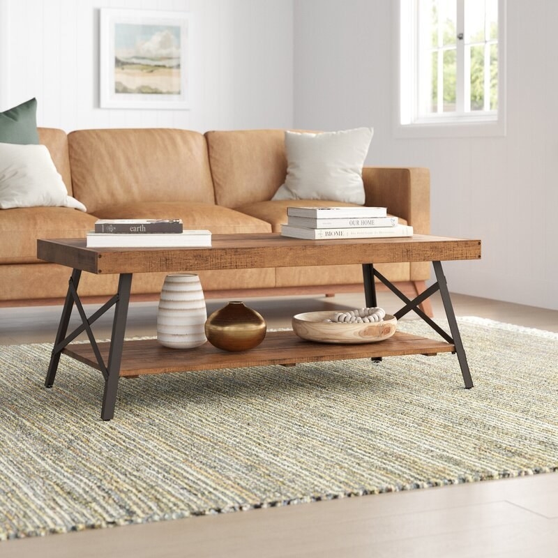 Coffee table shown with a sofa, rug and accessories