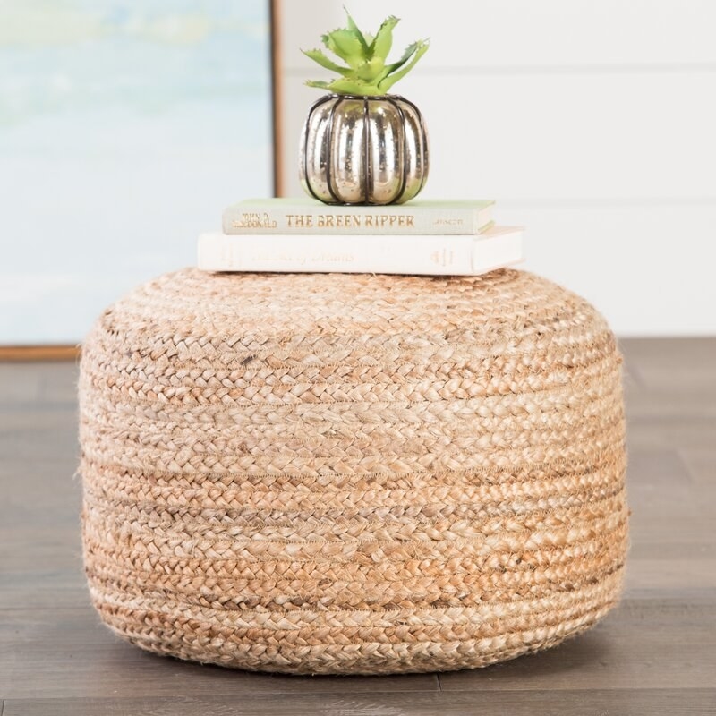 Woven round pouf with accessories on it