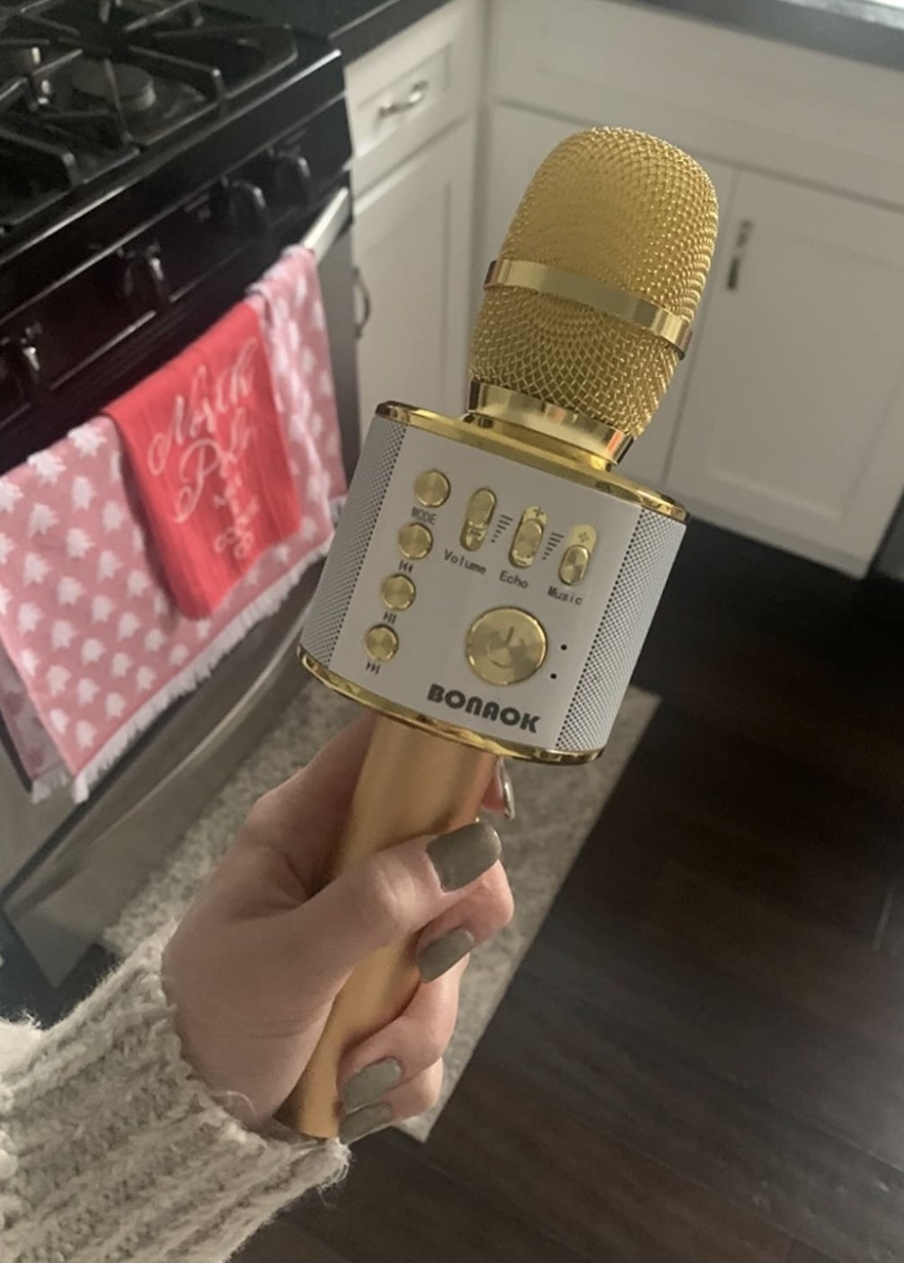 a reviewer holding their microphone in gold