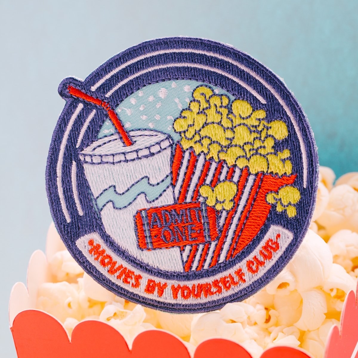 patch with popcorn, drink, and ticket that says &quot;movies by yourself club&quot;