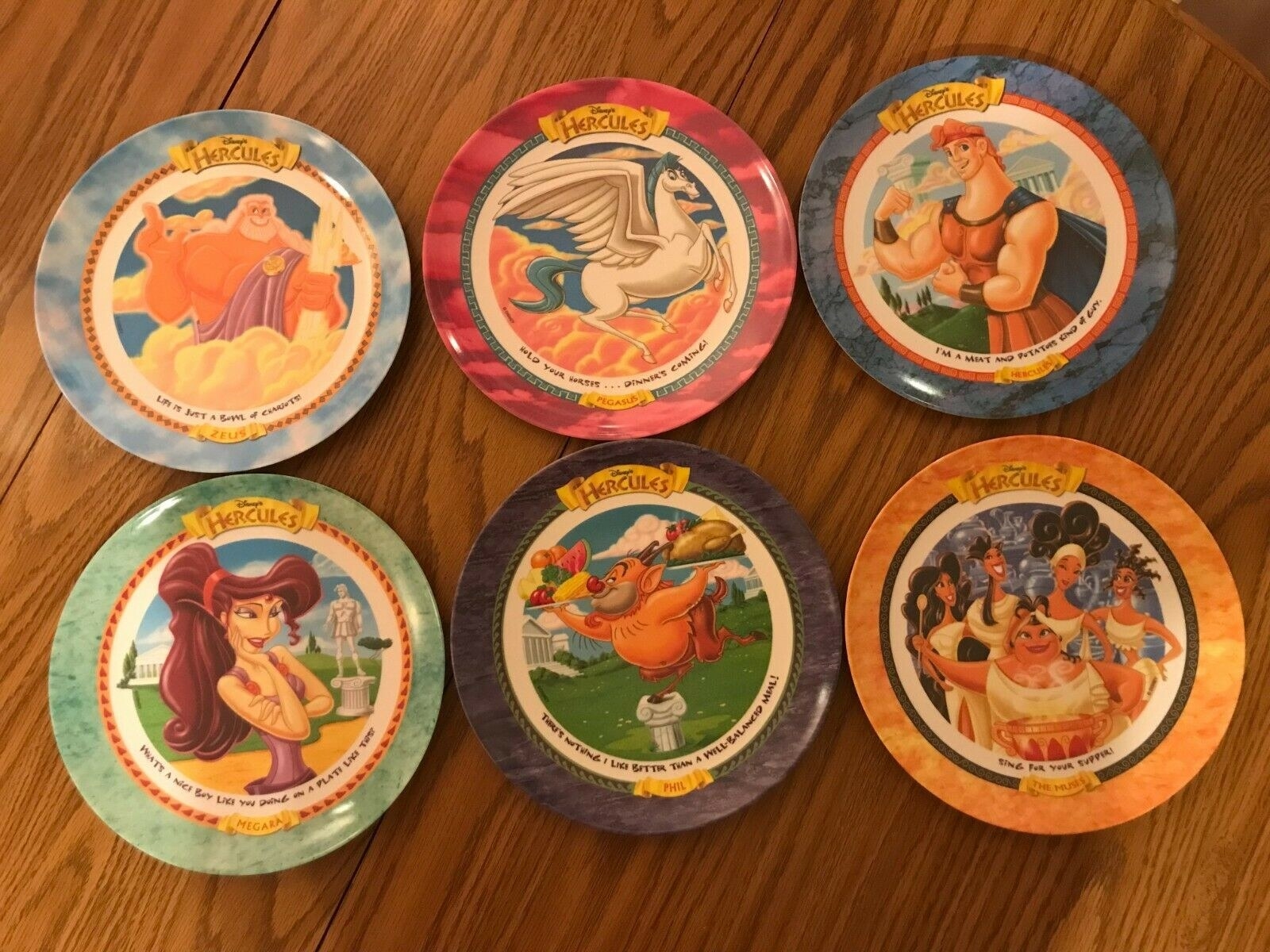 Six Hercules plates on a wooden table
